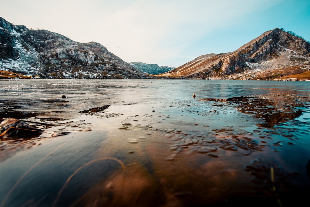 brown and white mountains near body of water during daytime