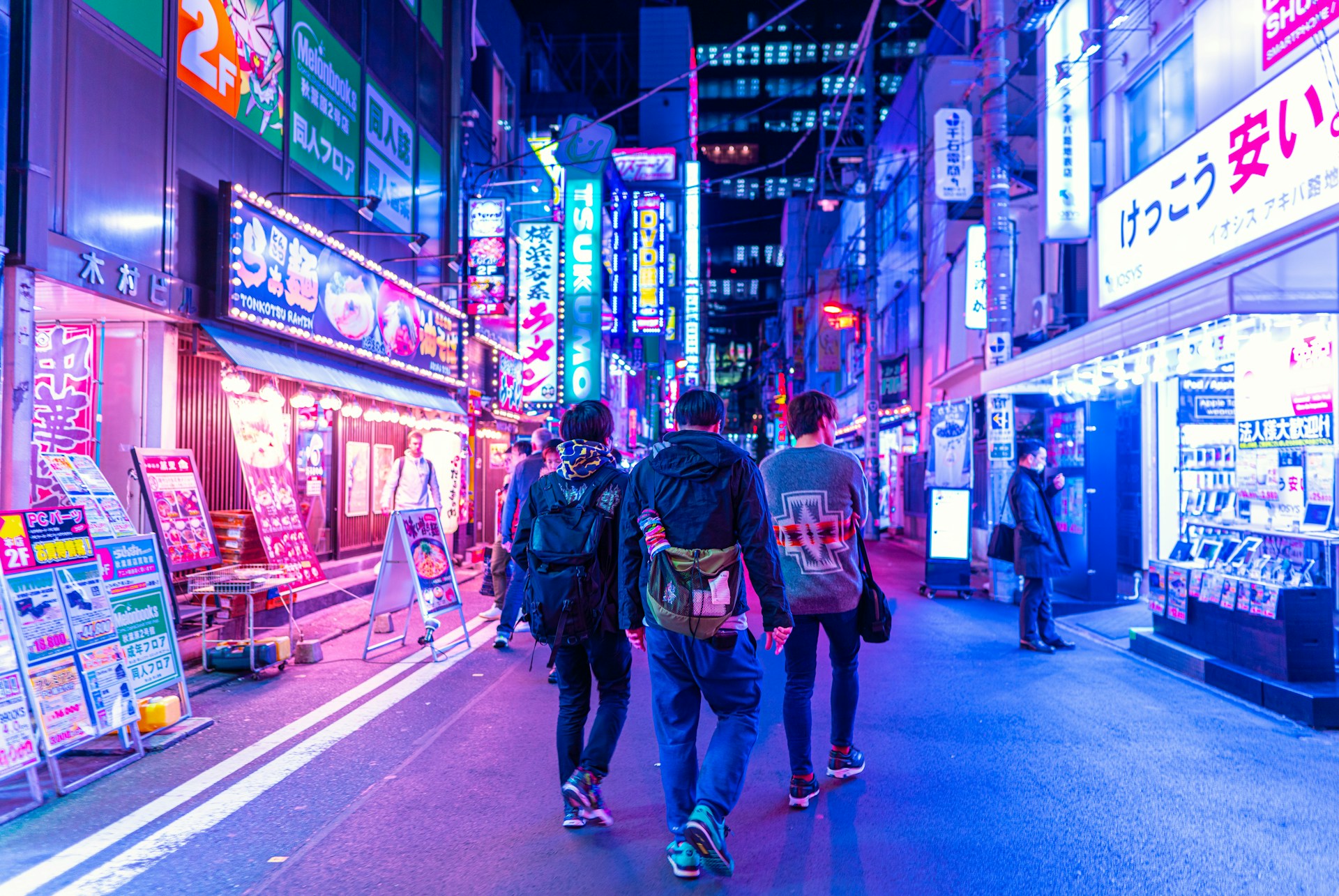 A close-up of colorful street art and neon signs illuminating the lively walkways of CyberHub at night.