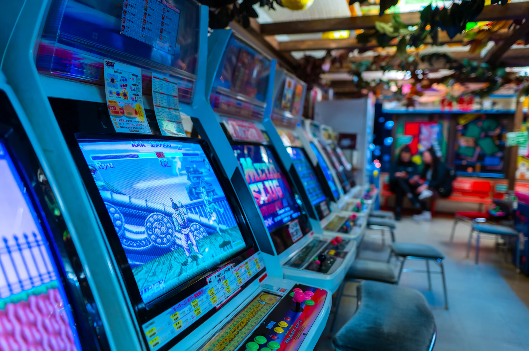 A row of classic arcade machines with bright screens