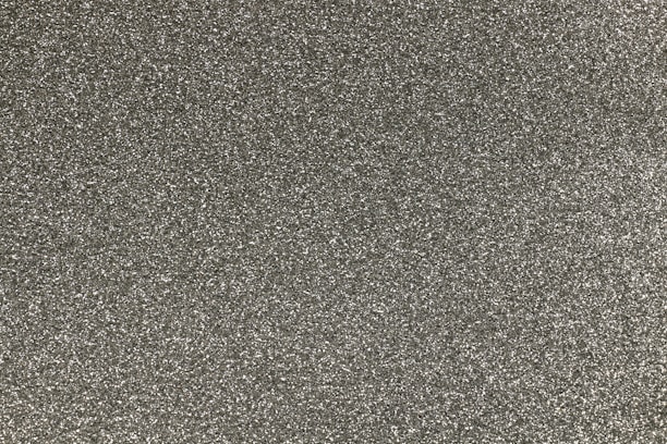 A close-up of high-purity silica grains on a textured surface.