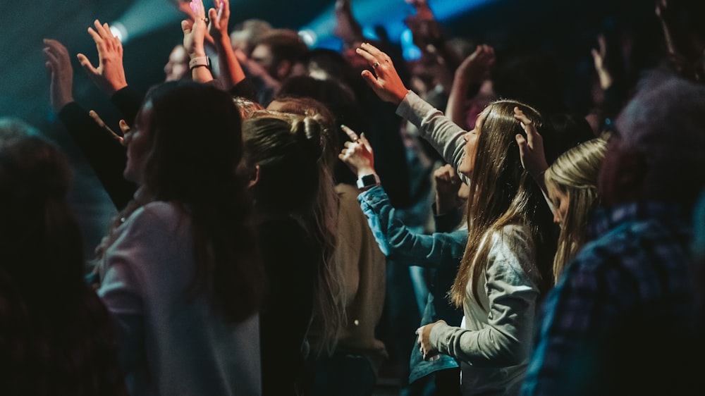 people raising their hands during nighttime