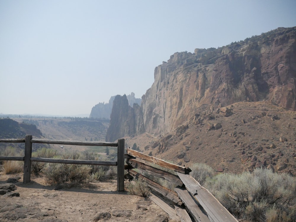 日中の茶色の岩層近くの茶色の木製のフェンス