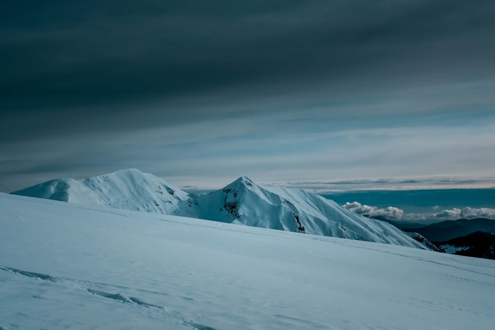 snow covered mountain under cloudy sky during daytime