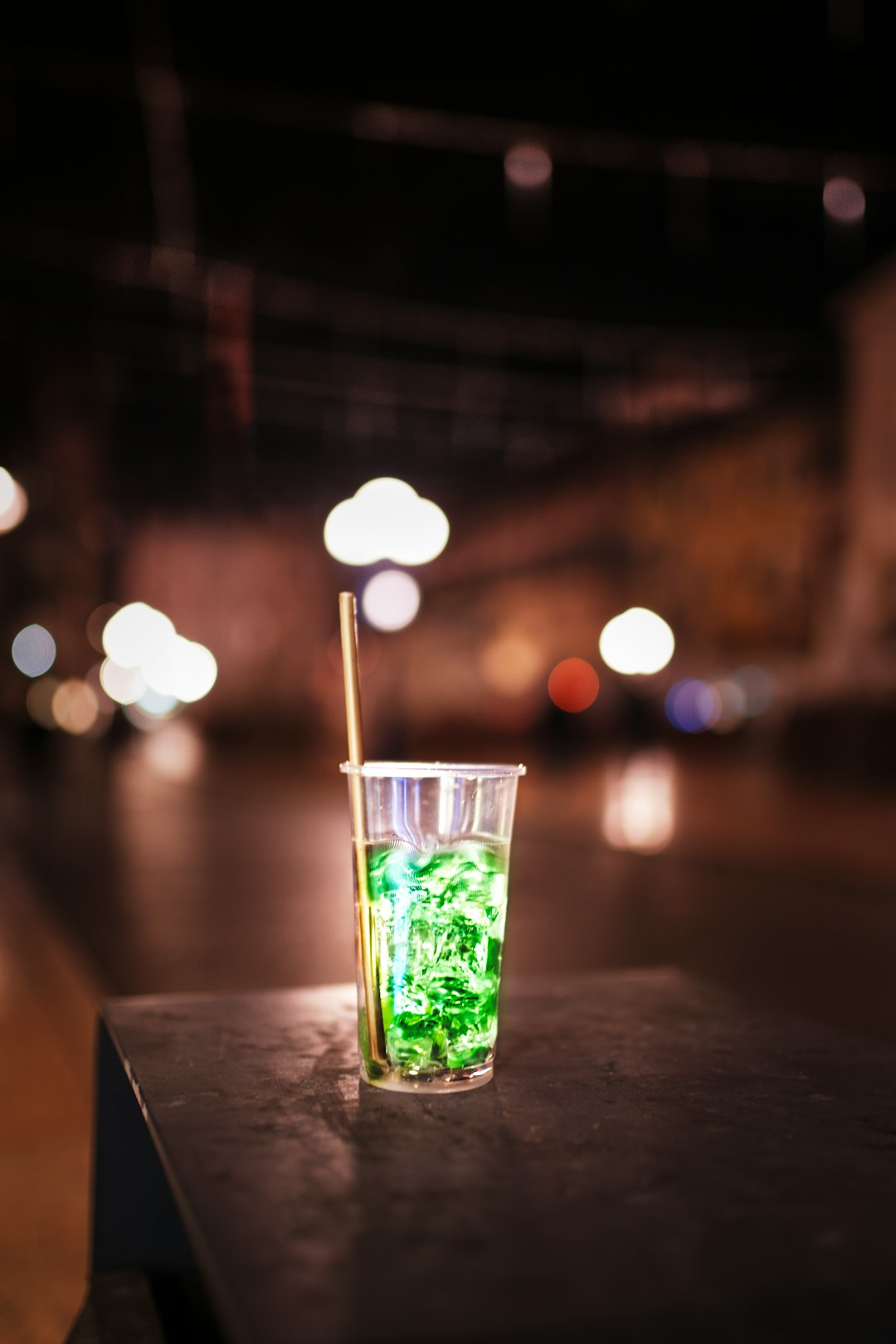 clear drinking glass with green liquid on brown wooden table