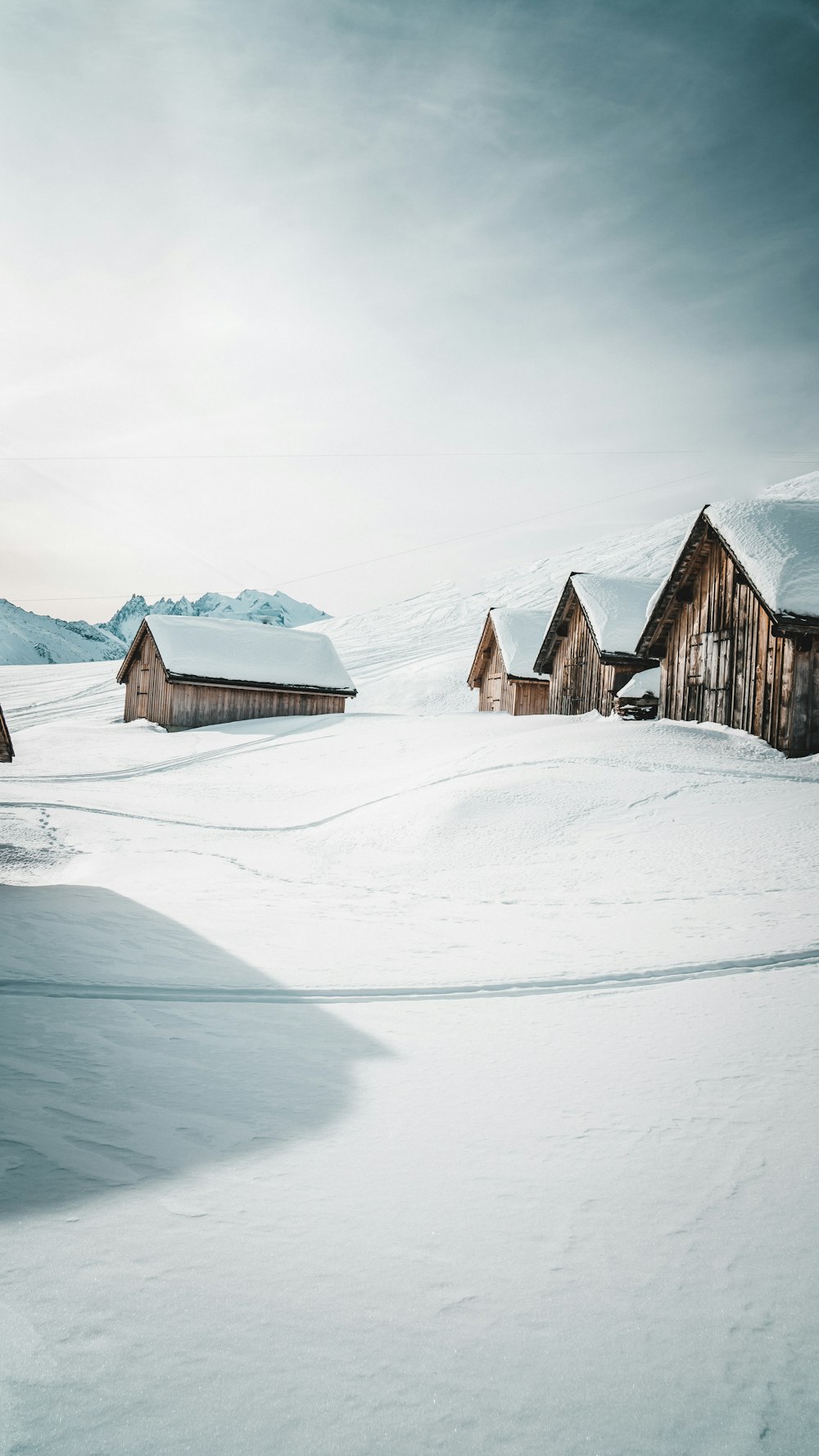 雪に覆われた地面に茶色の木造住宅