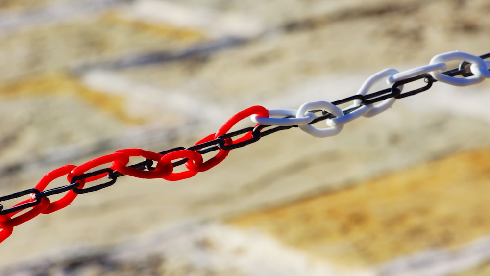 red and silver chain on brown wooden plank