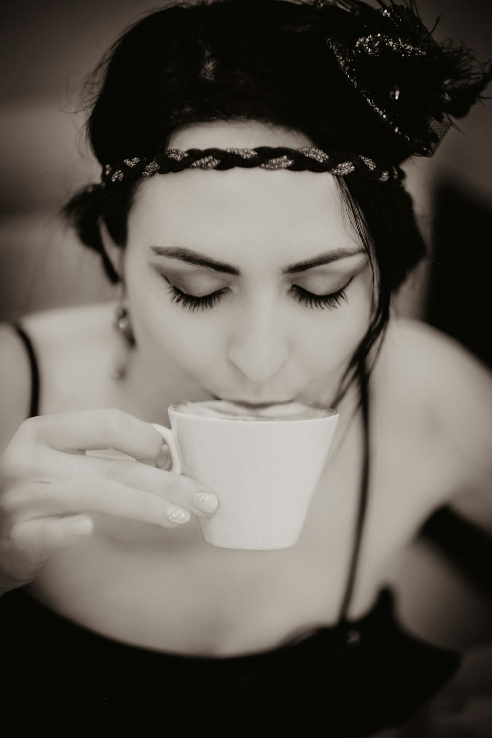 woman in black tank top holding white ceramic mug