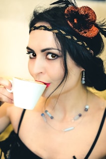 A chic lifestyle photo showing a woman wearing elegant accessories from l&i imports, holding a stylish printed cup.