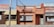 A row of small, rustic restaurants and shops with colorful signs, including a pizza place, lemonade stand, and chicken cafe. The buildings have a vintage aesthetic with signs advertising various foods like steak, cheese, and drinks.
