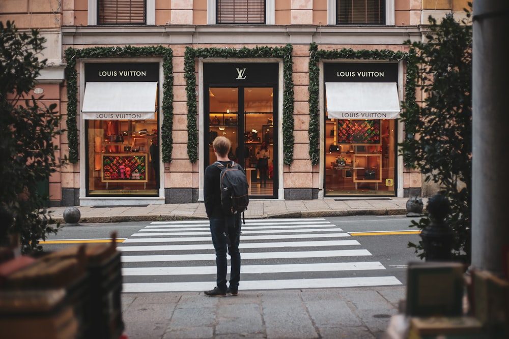 man in black jacket walking on pedestrian lane during daytime