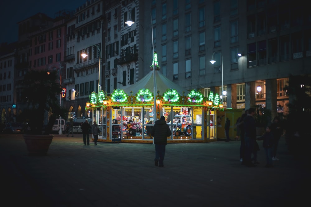 persone che camminano per strada durante la notte