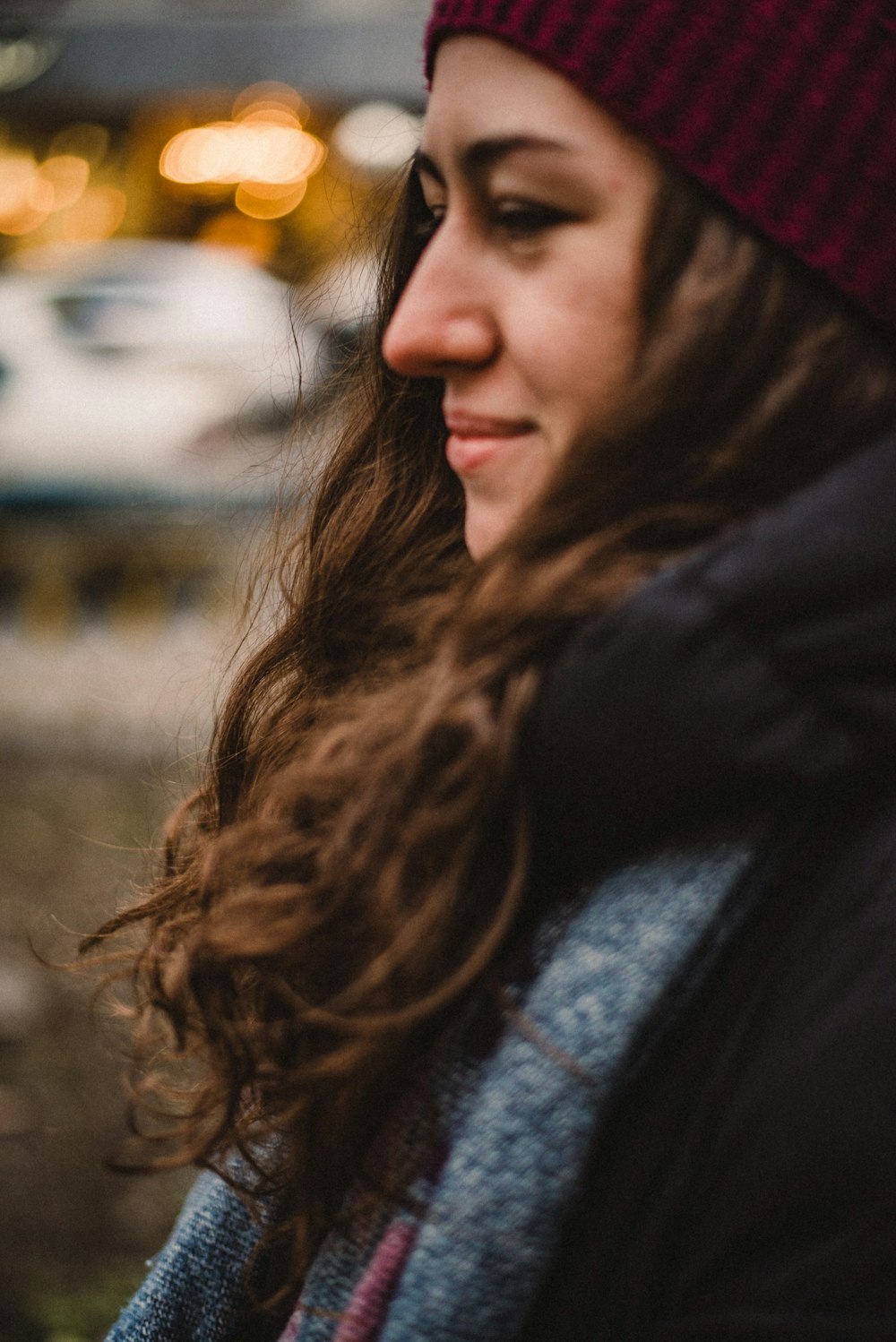 woman in black jacket and red knit cap