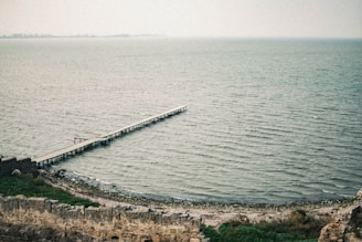 gray wooden dock on body of water during daytime