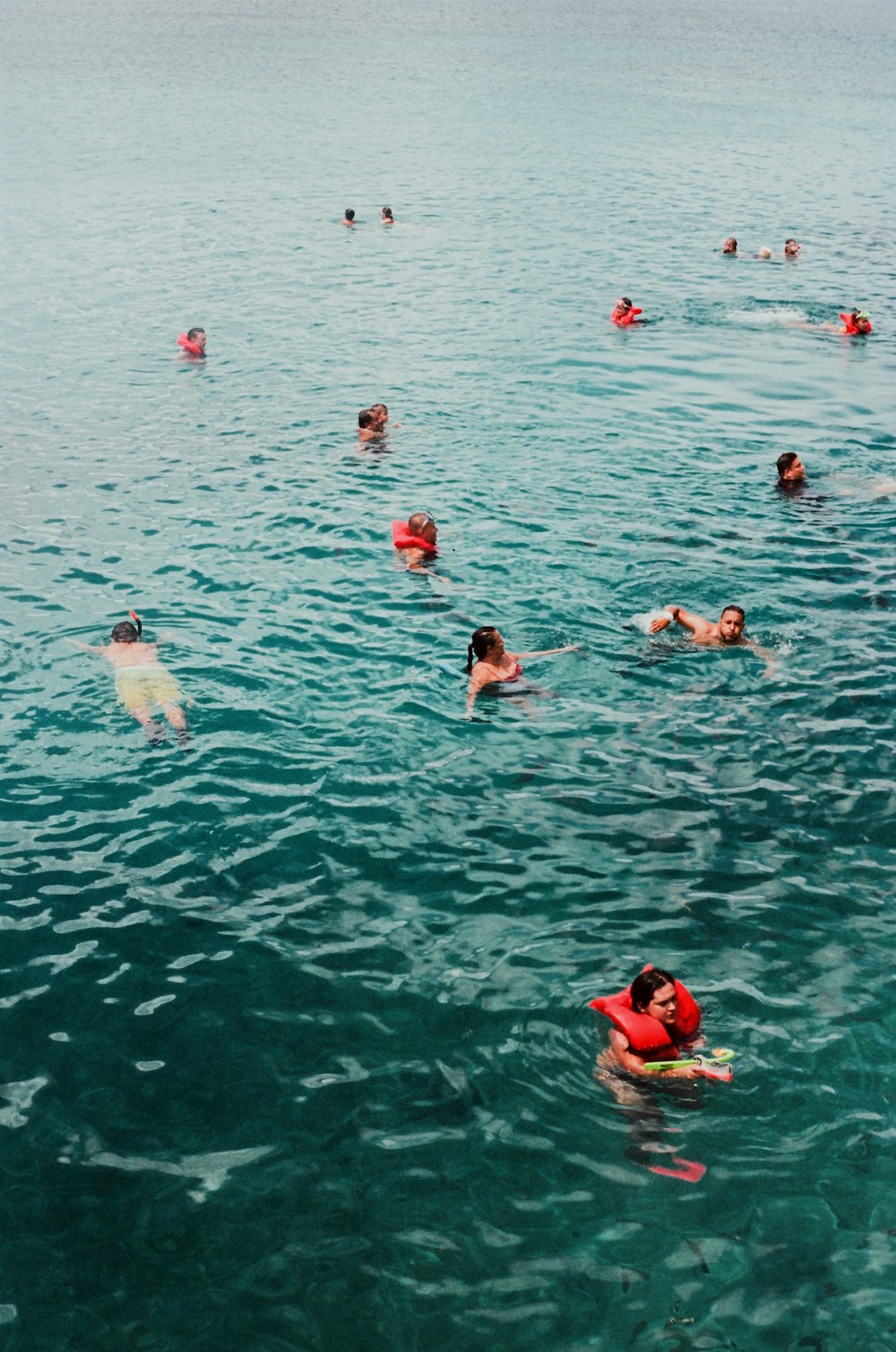 group of people swimming on water during daytime