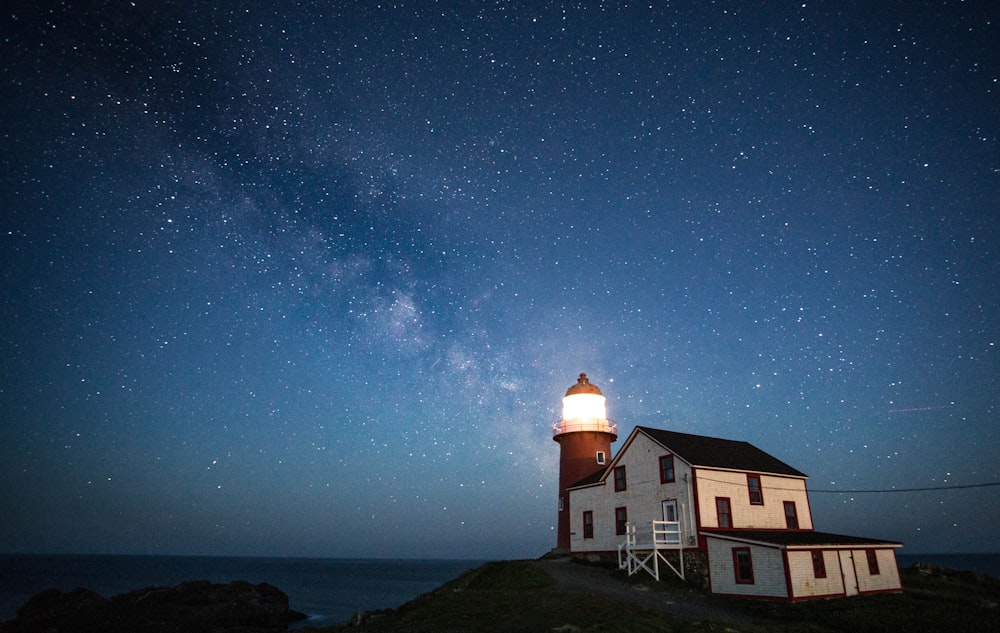 white and brown house near body of water under blue sky during night time