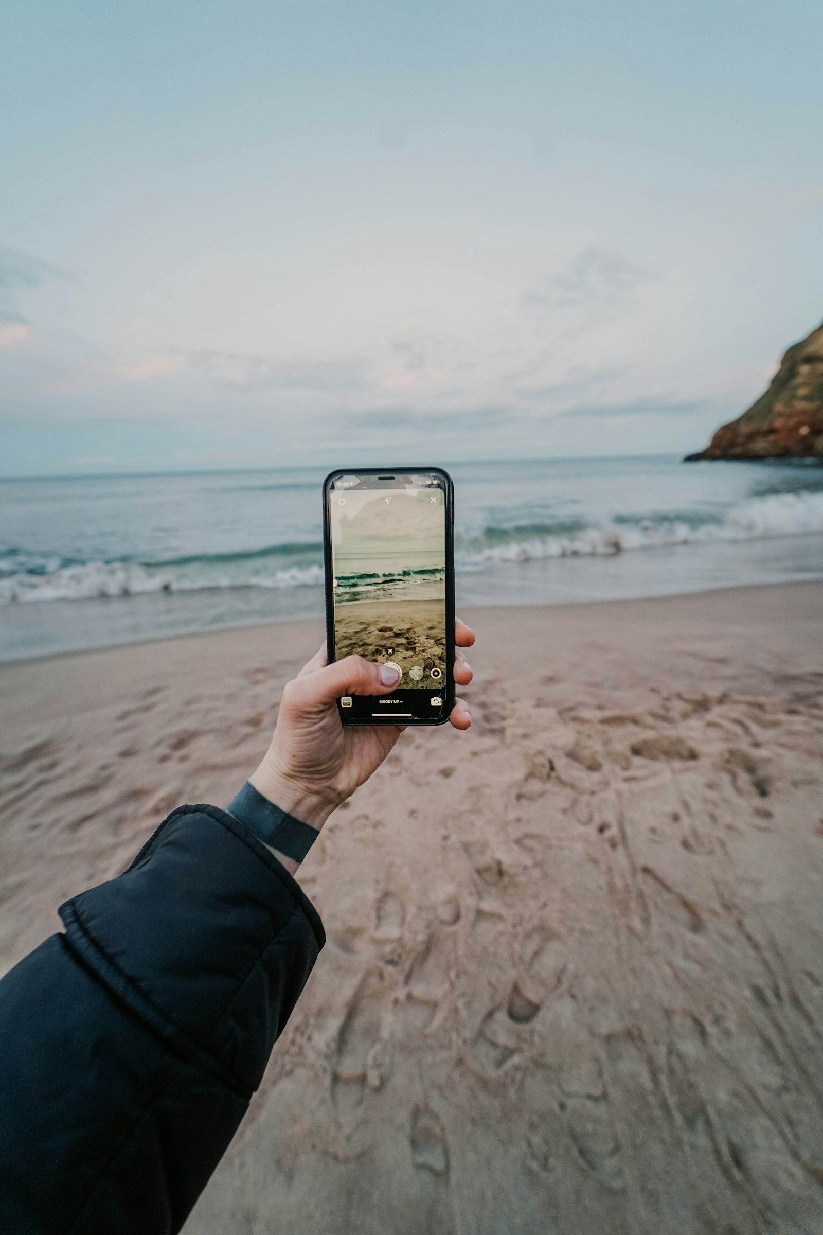 Sony a7 II + Samyang AF 14mm F2.8 FE sample photo. Person holding black iphone 5 photography