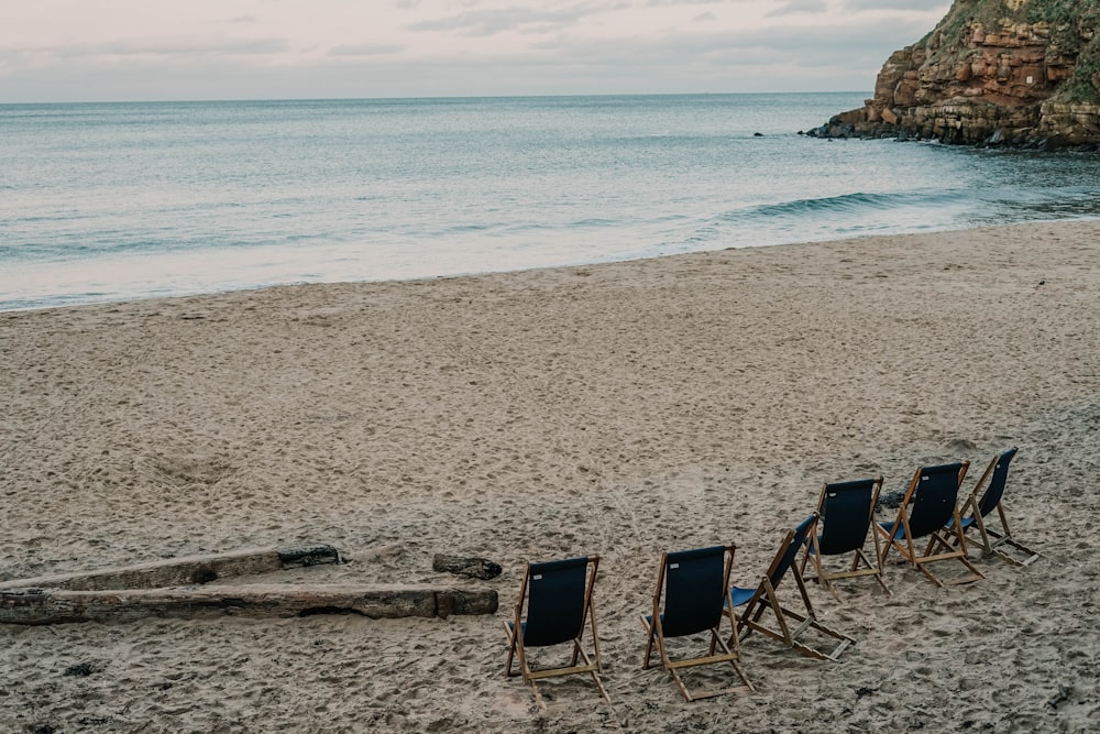 2 black and white folding chairs on beach during daytime