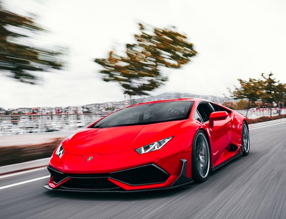 red ferrari sports car on road during daytime