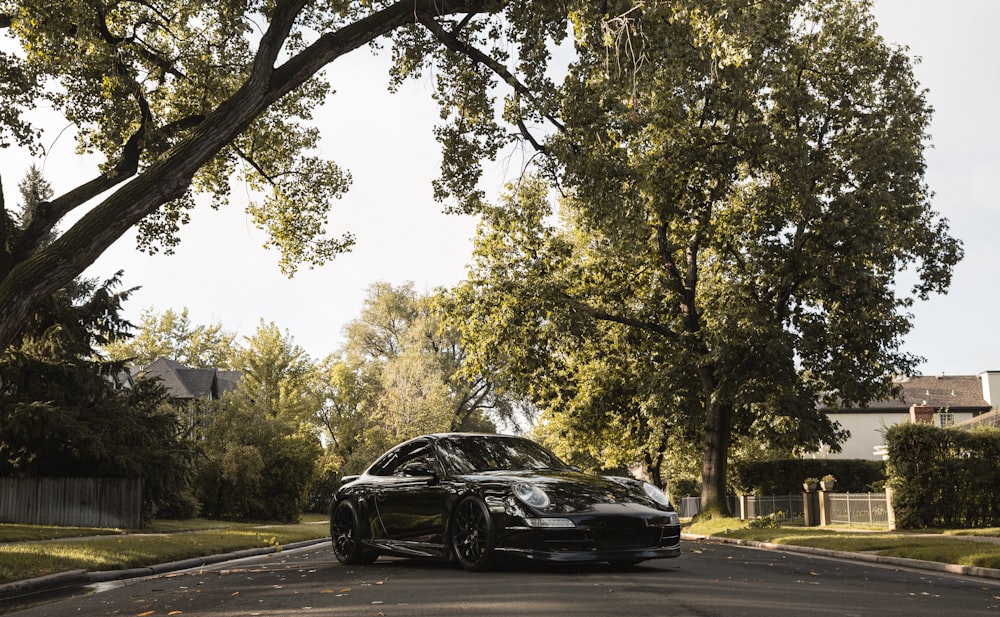 black car on road near trees during daytime