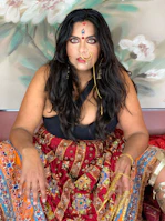 Vibrant ethnic wear featuring intricate patterns worn by a woman with natural makeup.