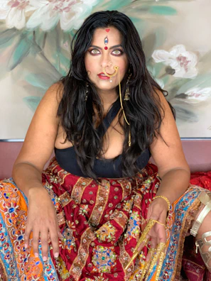 Vibrant ethnic wear featuring intricate patterns worn by a woman with natural makeup.