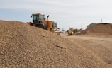 Workers guiding a Stonepath truck as it backs up to unload gravel.