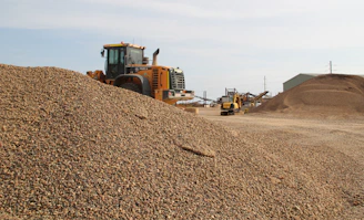 A sturdy dump truck parked on a gravel site under a clear blue sky in British Columbia.