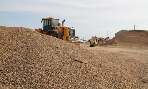 A sturdy dump truck parked on a gravel site under a clear blue sky in British Columbia.