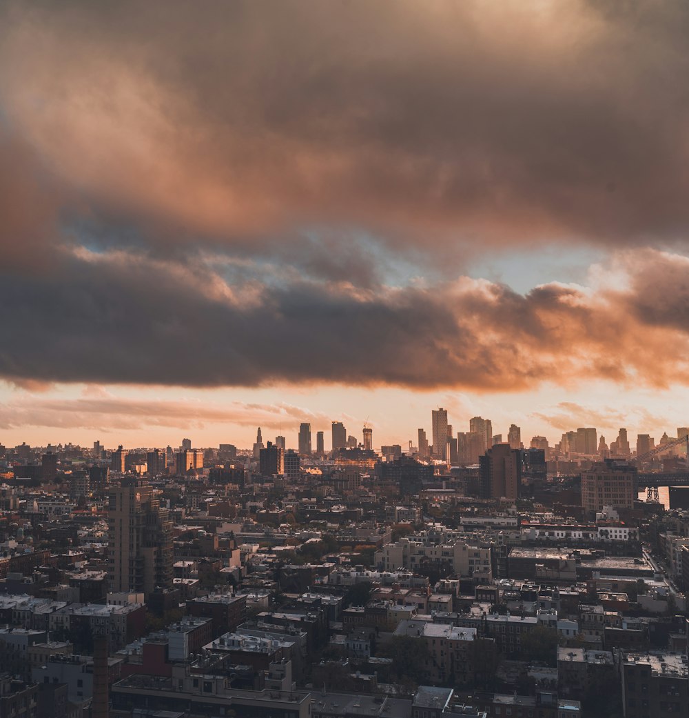 city skyline under cloudy sky during sunset