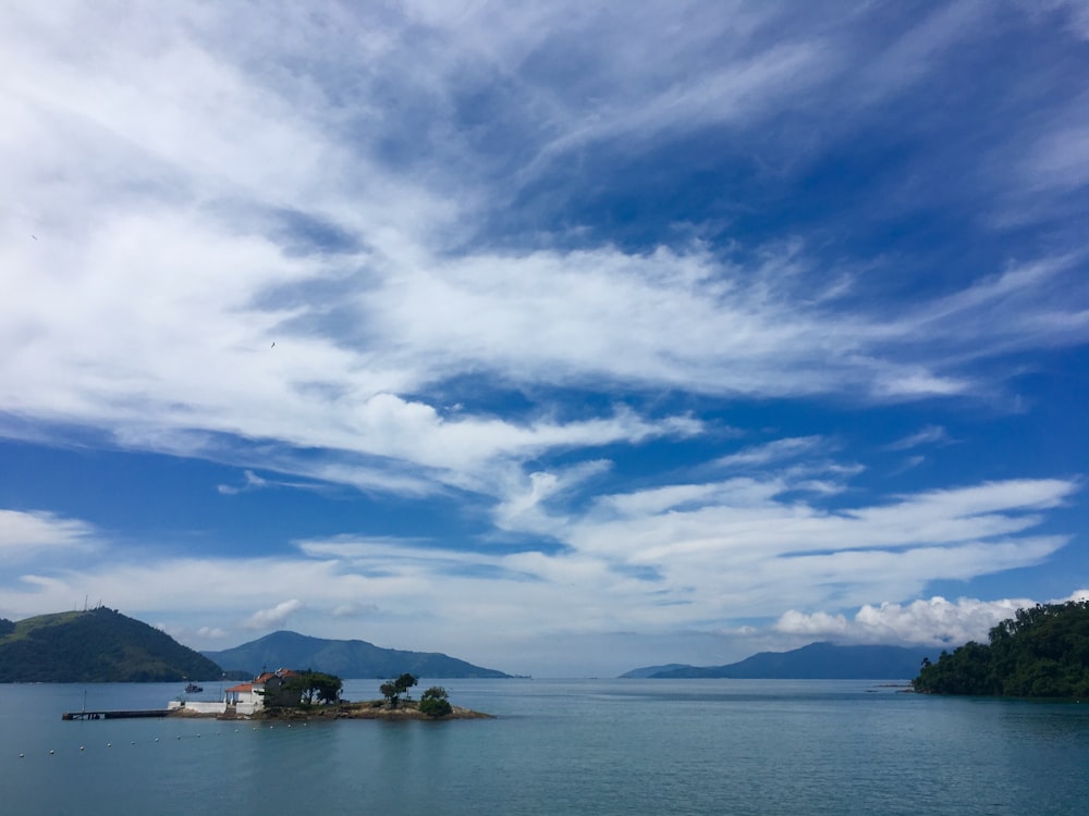 body of water under blue sky and white clouds during daytime