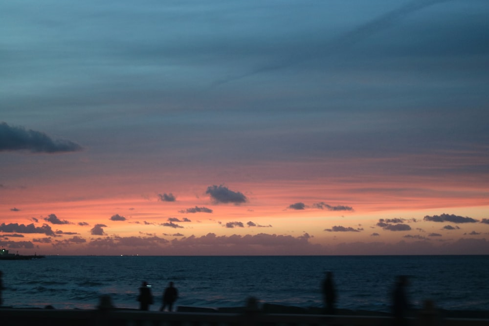 silhouette of people on beach during sunset