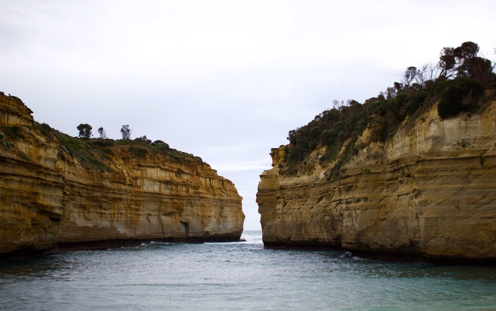 person standing on rock formation near body of water during daytime