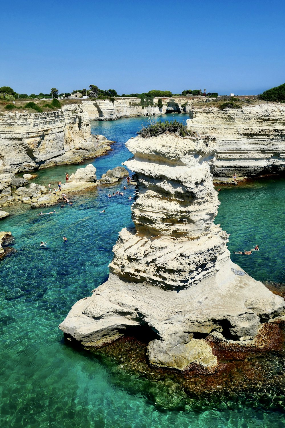 white and gray rock formation on body of water during daytime