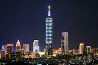 Nighttime cityscape highlighting luxury buildings and illuminated corporate towers.