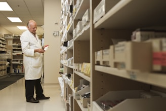 woman in white dress shirt and black pants standing near brown wooden shelf