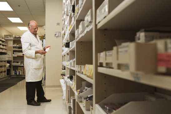Pharmaceutical scientists in lab coats carefully inspecting medicinal products in a bright, modern lab.