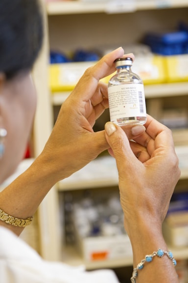 person holding white labeled medicine bottle