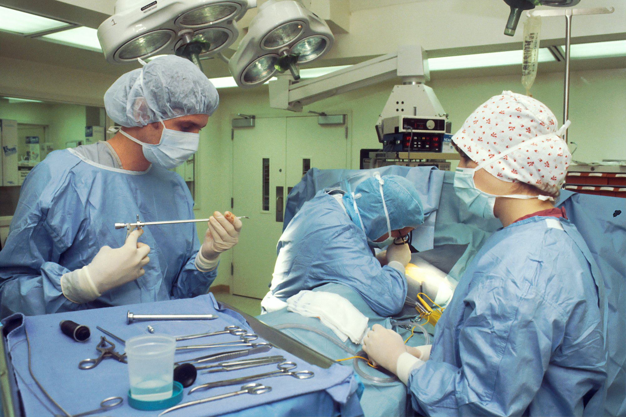 Two surgeons and a nurse performing a Thoracoscopy by which they are examining the pleural cavity by means of an Endoscope to later perform a biopsy.