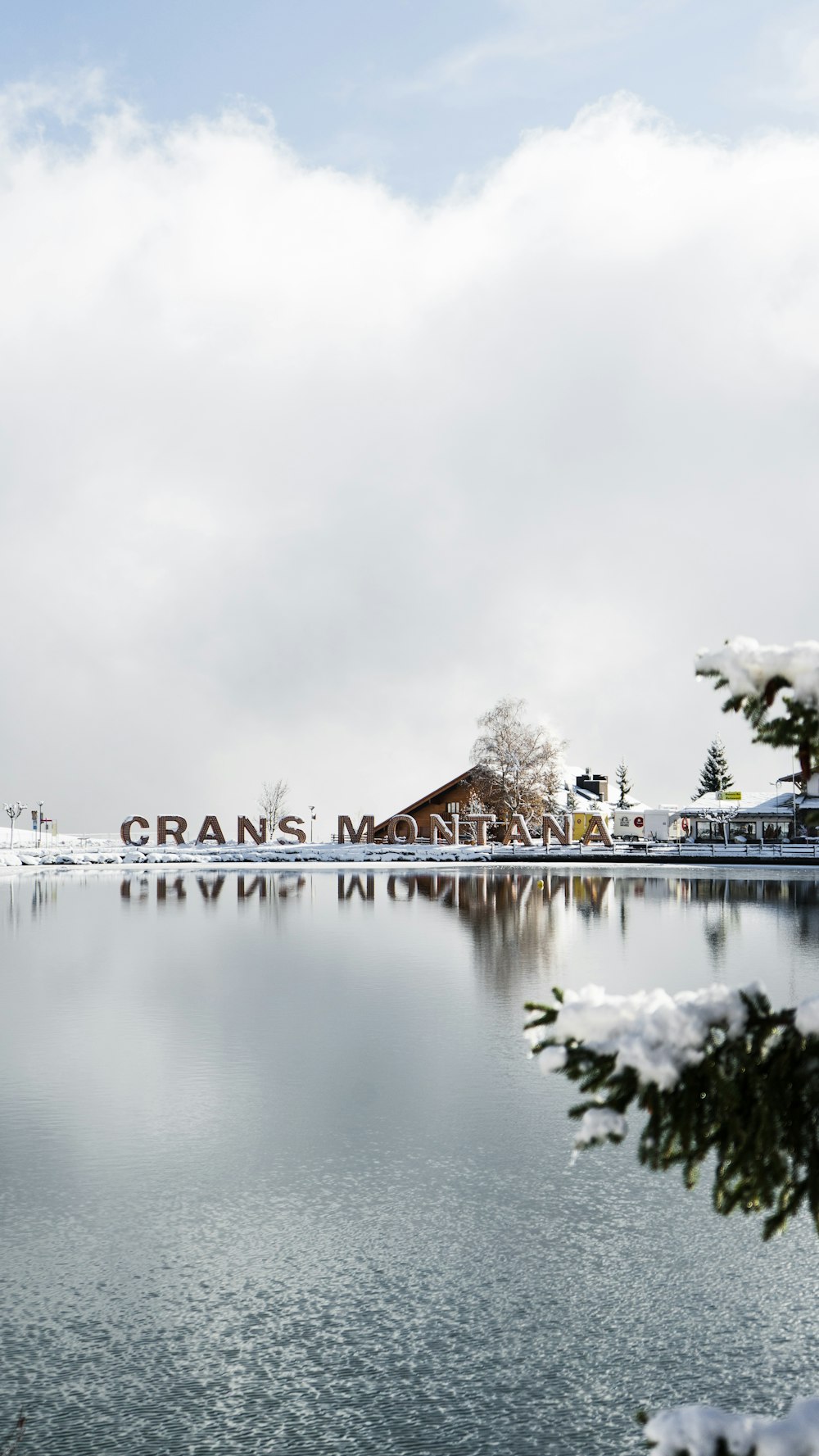 brown house near body of water under white sky during daytime