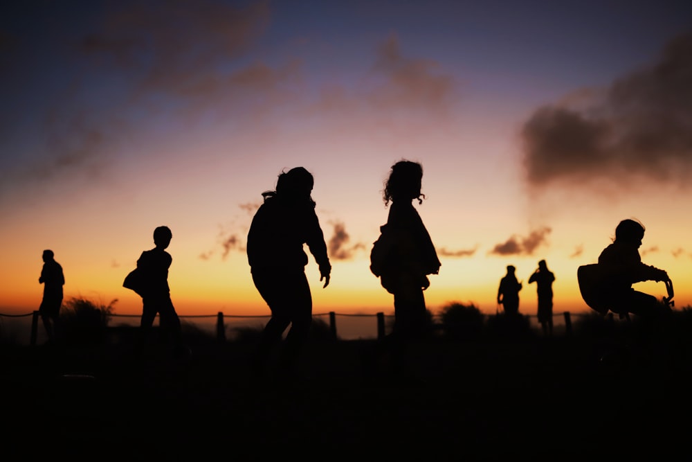 silhouette of people standing during sunset