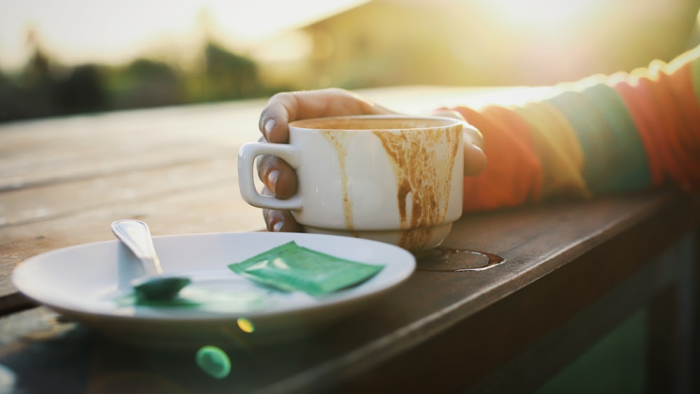 white ceramic mug on brown wooden table