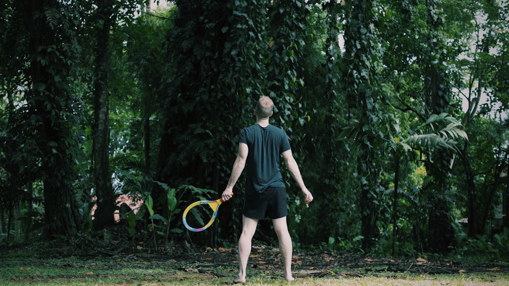 man in black crew neck t-shirt and black shorts playing with yellow and green basketball