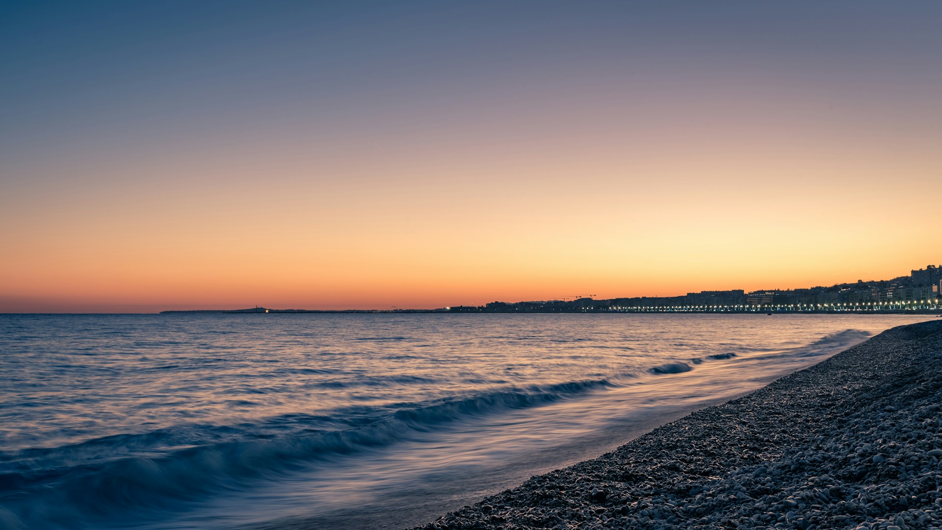 sea waves crashing on shore during sunset