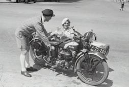man in gray jacket and black cap riding black motorcycle