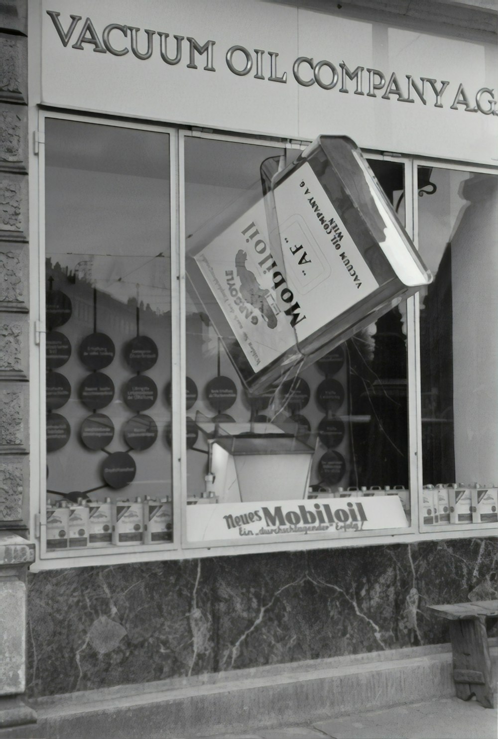 grayscale photo of man and woman in front of glass window