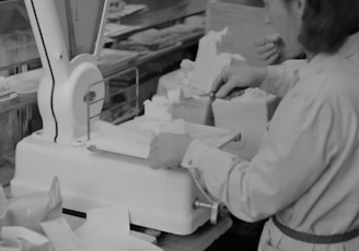 girl in white long sleeve shirt standing in front of white printer paper