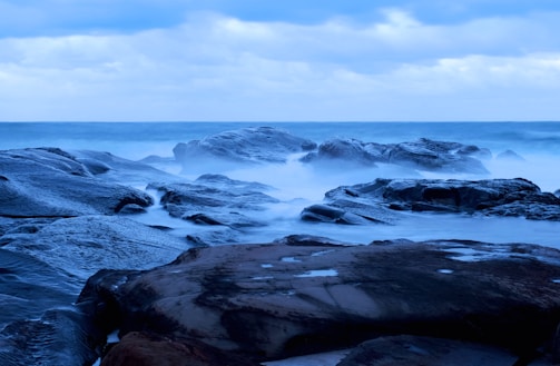 A misty Australian coastline at dawn, waves crashing softly.