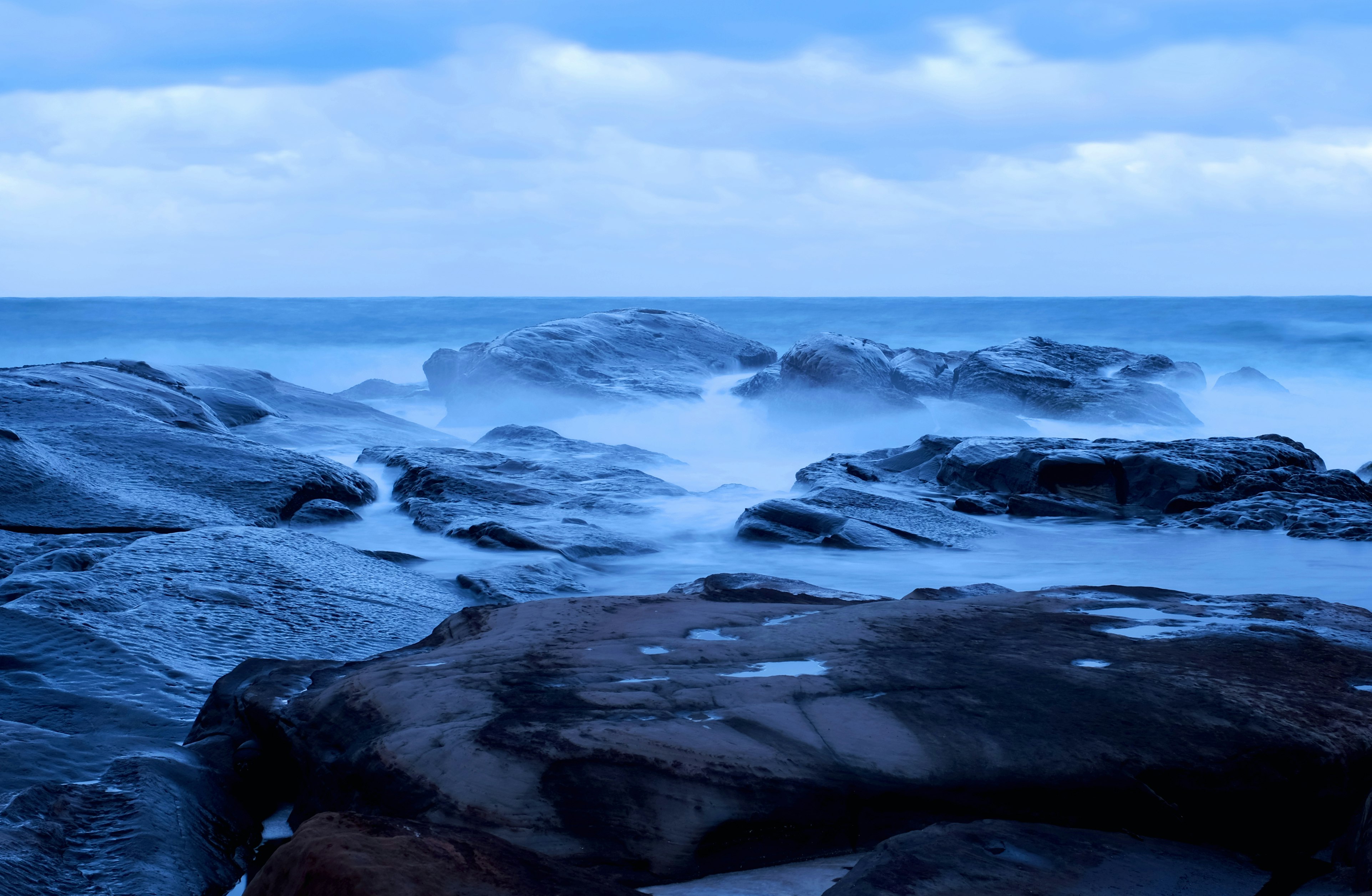 rocky shore under cloudy sky during daytime