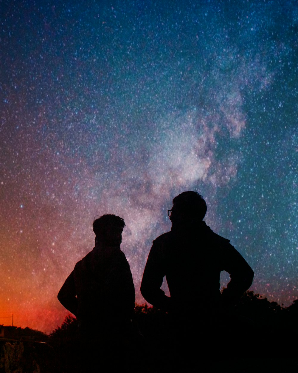 silhouette of man standing under starry night