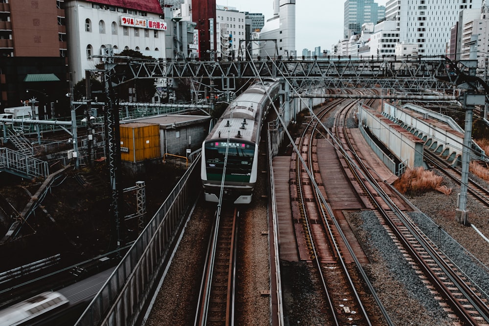 green and white train on rail tracks during daytime